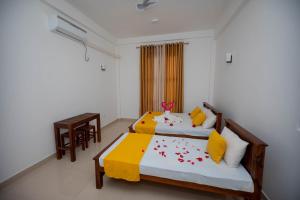 1 Schlafzimmer mit 2 Betten, einem Tisch und Stühlen in der Unterkunft Ehala Family Rest in Anuradhapura