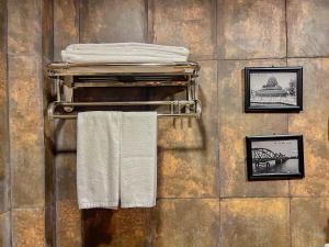 uma casa de banho com duas toalhas e fotografias numa parede em Moly Resort em Kampot