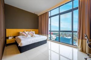 ein Schlafzimmer mit einem Bett und einem großen Fenster in der Unterkunft Greystone 99 Suites in Malakka
