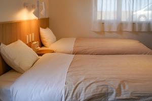 pokój hotelowy z 2 łóżkami i oknem w obiekcie Beach SPA TSUDA 1 Uno w mieście Sanuki