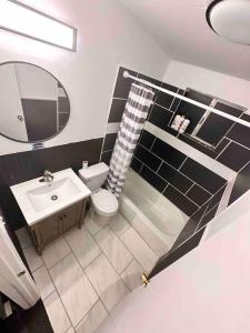 een badkamer met een wastafel, een toilet en een spiegel bij La casita Blanka in Las Cruces