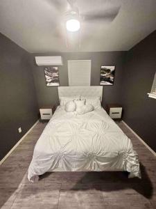 een slaapkamer met een groot wit bed en 2 tafels bij La casita Blanka in Las Cruces