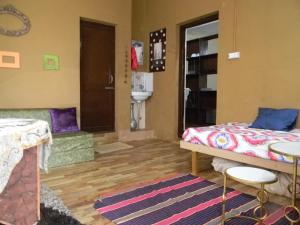 Una habitación con una cama y un sofá. en Hillock By In Vogue, en Dharamshala