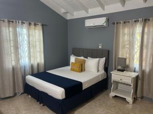 a bedroom with a large bed with a nightstand and a bed sidx sidx sidx at Williams Oasis in Falmouth