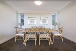 a dining room with a wooden table and chairs at Palm Springs - Hosted by Burleigh Letting in Gold Coast