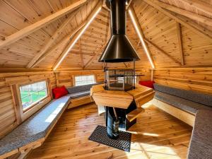 a room in a log cabin with benches and a chandelier at Bespoke Holiday Home With Private Pool And Hot Tub, Sleeps 8 Ref 34073p in King's Lynn