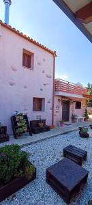 ein Gebäude mit einer Terrasse mit Bänken und einem Gebäude in der Unterkunft George & Helen's House in Ayiá