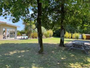 twee bomen en een picknicktafel in een park bij Prignac en médoc-maison-6 pers-3ch-piscine chauffée 
