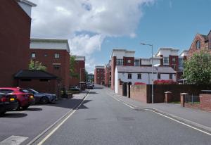 uma rua vazia com edifícios e carros estacionados nela em Albion Street Apartments em Wolverhampton
