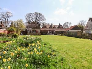 a yard with flowers in front of a house at Cupid's Cottage in Bessingby