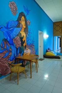 a room with a mural of a woman on the wall at Snooze Malang in Malang