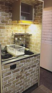 eine Backsteinküche mit einer Spüle und einem Herd in der Unterkunft Guest House Yakuin INN in Fukuoka