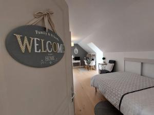 - une chambre avec un lit et un panneau de bienvenue sur le mur dans l'établissement Detente a la campagne, à Myennes