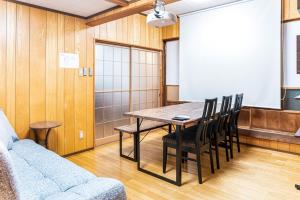 ふるシェアの家すさみ في Susami: قاعة اجتماعات مع طاولة وكراسي وشاشة عرض