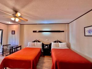 Habitación de hotel con 2 camas y ventilador de techo. en Hotel Boutique Tehuacan, en Tehuacán
