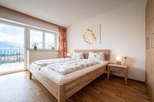 a bedroom with a bed and a large window at Ferienwohnungen Plattnerhof in Terfens