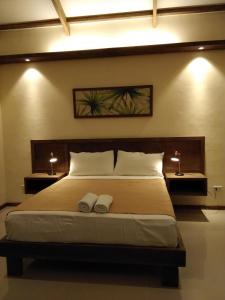 um quarto com uma cama grande e 2 almofadas brancas em Forest garden residence em Bilar