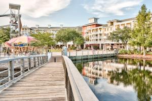 a wooden walkway next to a river with buildings at Grand Sandestin #2317 in Destin