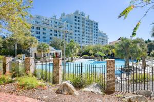 una valla frente a un edificio con piscina en Grand Sandestin #2317 en Destin