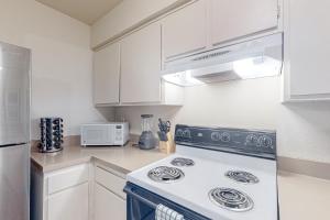a white kitchen with a stove and a microwave at The Heart of Mission Valley in San Diego