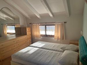 um quarto com uma cama, uma cómoda e um espelho em Casa Vio em Calceranica al Lago