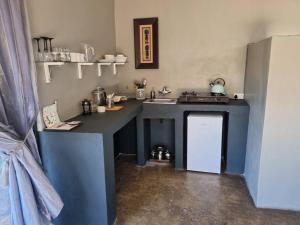 La cuisine est équipée d'un comptoir bleu et d'un évier. dans l'établissement Hackberry House Black Thorn Cottage, Off Grid, à Khemsbok