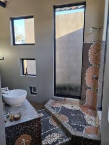 y baño con ducha y lavamanos. en Hackberry House Black Thorn Cottage, Off Grid en Khemsbok