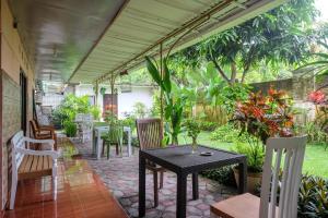 a patio with tables and chairs and plants at RedDoorz Syariah @ Colomadu 2 in Solo