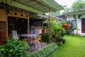 a patio with a table and chairs and plants at RedDoorz Syariah @ Colomadu 2 in Solo