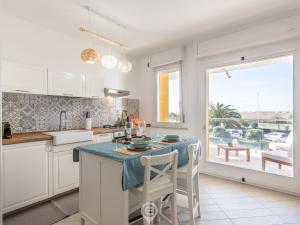 een keuken met een eiland met een blauw aanrecht bij Poetto Panoramic Apartment in Su Forti
