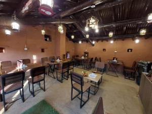 un restaurante con mesas y sillas en una habitación en FOREST ACRES CAMPS en Mukteswar