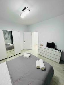 um quarto branco com uma cama com duas almofadas em Apartament cu 2 camere Giroc em Giroc