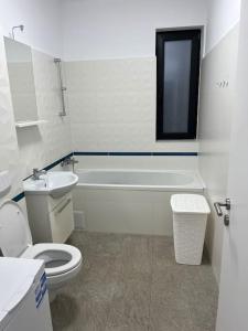 uma casa de banho com um WC, uma banheira e um lavatório. em Apartament cu 2 camere Giroc em Giroc