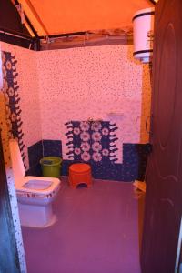 a bathroom with a toilet in a room at FOREST ACRES CAMPS in Mukteswar