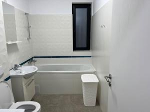 a bathroom with a tub and a toilet and a sink at Apartament cu 2 camere Giroc in Giroc