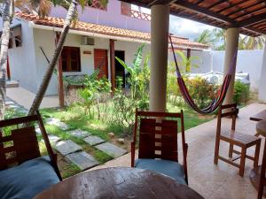 a patio with a table and chairs and a house at Aloha Kite House in Lagoinha