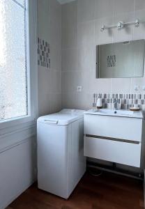 a white bathroom with a sink and a mirror at Vivez le Port de plaisance - Plage in Le Havre