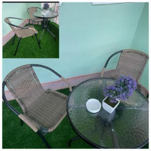 een glazen tafel en twee stoelen en een tafel met bloemen bij Modern & Homely Suite with Free Parking & WiFi in Embu