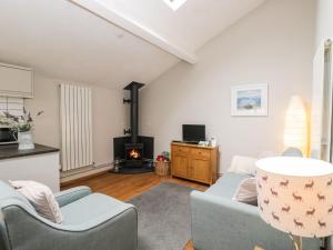 a living room with a couch and a fireplace at Bower Coach House in Martock