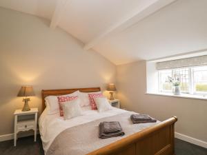 a bedroom with a large bed with a window at Bower Coach House in Martock