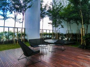 a patio with chairs and a table on a wooden deck at The Hub SS2 - Studio Suite Room in Kuala Lumpur