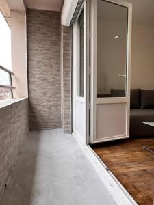 pasillo con puerta de cristal y sofá en SENS - Appartement Proche Gare et Centre ville, en Sens