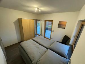 ein kleines Schlafzimmer mit einem Bett und zwei Fenstern in der Unterkunft Ferienwohnung '' Wein unter Palmen '' in Neumagen-Dhron