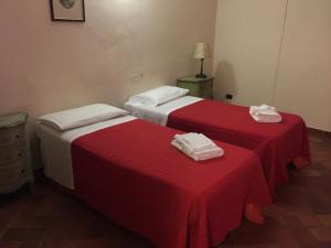 two beds in a room with red and white sheets at Hotel Le Due Fontane in Florence
