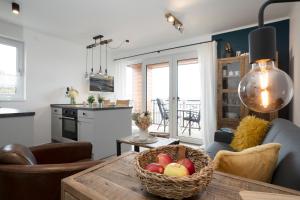 a kitchen and living room with a basket of fruit on a table at Residenz am Yachthafen Seaside Marina in Neustadt in Holstein