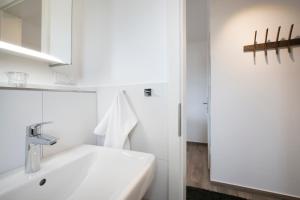 a white bathroom with a sink and a mirror at Residenz am Yachthafen Seaside Marina in Neustadt in Holstein