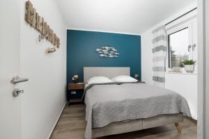 a bedroom with a bed and a blue wall at Residenz am Yachthafen Seaside Marina in Neustadt in Holstein