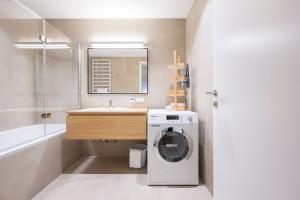 a bathroom with a washing machine and a sink at Luxury Suites Renngasse in Vienna