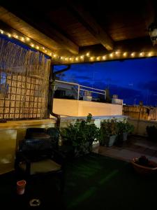 a patio with lights and a balcony with a table and chairs at La piccola terrazza in Bari
