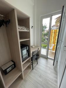 a room with a tv and a desk with a chair at Hotel Deutsche Familien in Finale Ligure